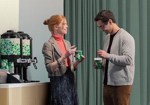 Two colleagues speak next to Chameleon self-serve coffee station