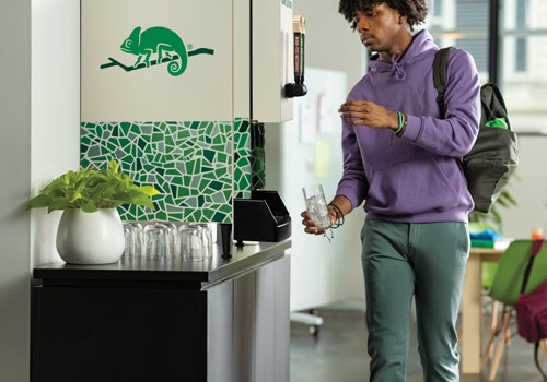 Man pours cup of Chameleon Cold Brew from countertop solution