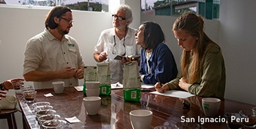 Men and Women Gathered Around a Table Testing the Quality of Different Coffees in San Ignacio, Peru