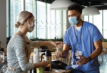 Barista Serves Doctor a Cup of Starbucks Coffee in a Hospital Cafeteria