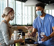 Barista Serves Doctor a Cup of Starbucks Coffee in a Hospital Cafeteria