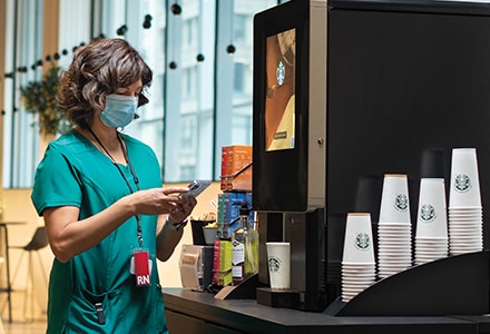 Nurse Using Starbucks Serenade Coffee Machine in Hospital