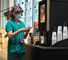 Nurse Using Starbucks Serenade Coffee Machine in Hospital