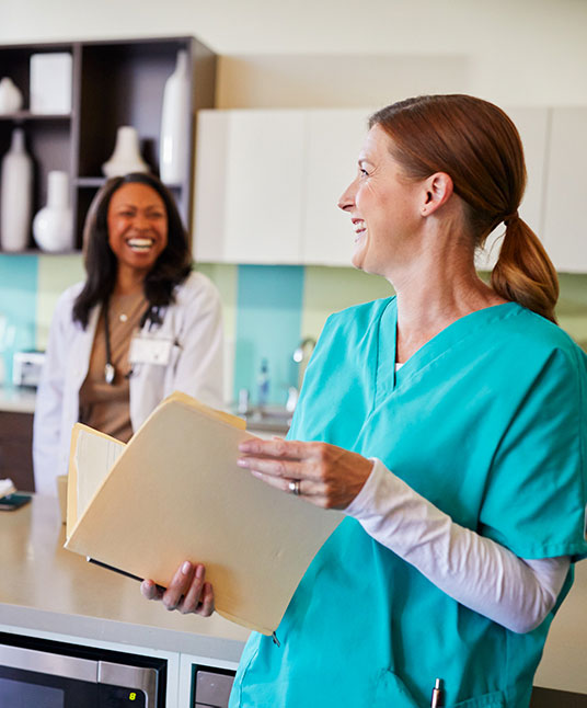 Two Women, a Doctor and a Nurse, Laughing Together at Work