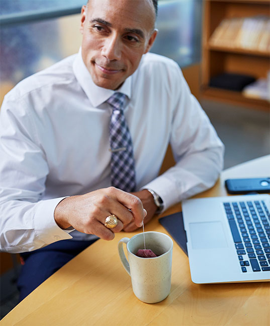 Man Enjoying Mug of Hot Tea at Work